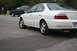 2003 Acura TL - Rear 3/4 view of a white 2003 Acura TL parked on asphalt, with a black SUV in the background.