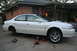 2003 Acura TL - A white 2003 Acura TL is shown on jack stands with the front passenger wheel removed for maintenance.