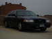 1998 Ford Crown Victoria - A black Ford Crown Victoria is parked in a lot with a brick building in the background.