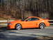 1995 Ford Mustang - Side view of an orange 1995 Ford Mustang coupe.