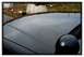 1998 Ford Crown Victoria - A close-up view of a car's hood and side mirror, with concrete barriers visible in the distance.