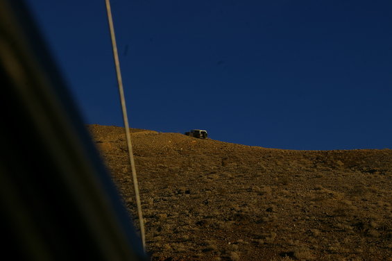 SUV on a dry, grassy hill under a clear blue sky