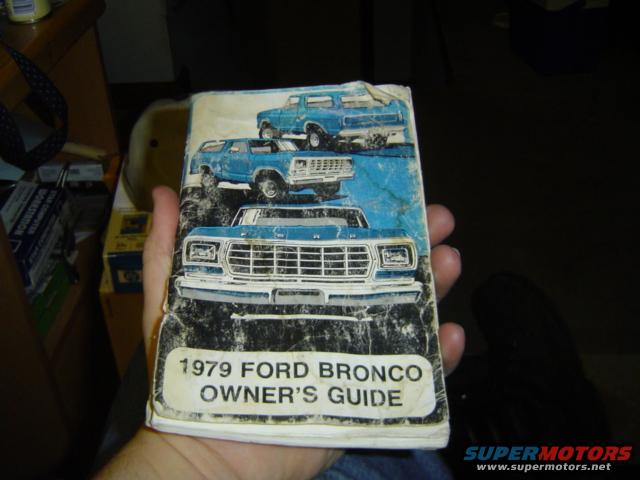 Owner's guide document with illustrations of blue Ford Broncos, text reads '1979 Ford Bronco Owner's Guide'
