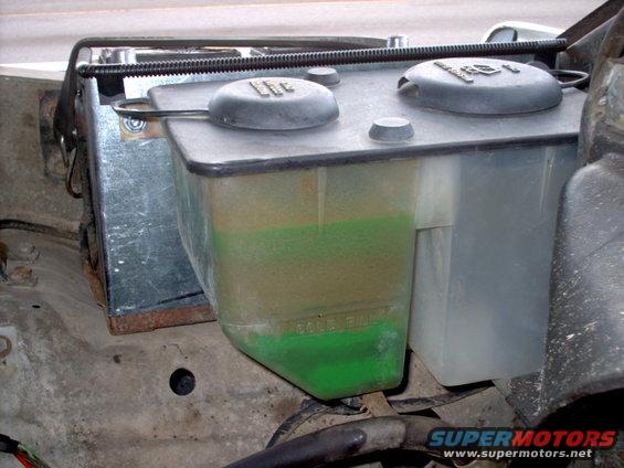 Windshield washer fluid reservoir with green fluid, "FULL" marking visible