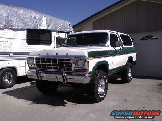 White and green 1978 Ford Bronco with a license plate reading '78 BRONCO', parked in a driveway