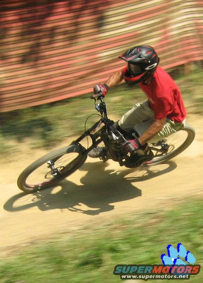 Mountain biker in red shirt and helmet on dirt track, motion blur