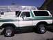 1978 Ford Bronco - This two-tone Ford Bronco is parked in a driveway with a recreational vehicle behind it.