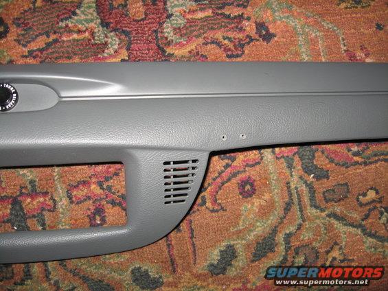 Close-up of gray plastic car interior trim with a vent and two screw holes