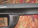 2004 Ford Crown Victoria - A close-up view of a car's interior dashboard trim piece, a small vent, is shown against a patterned carpet background.