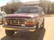 1992 Ford Bronco - This red 1992 Ford Bronco features a prominent chrome grille and square headlights.