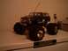 1991 Ford Bronco - A blue remote control monster truck sits on a shelf, its large tires dominating the frame.