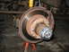 1995 Ford C-350 (Centurion Conversions) - Close-up of a vehicle's front wheel hub and brake assembly, supported by a red jack stand.