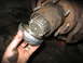1995 Ford C-350 (Centurion Conversions) - Close-up of a vehicle's front wheel hub assembly with a cap being removed, revealing internal splines.