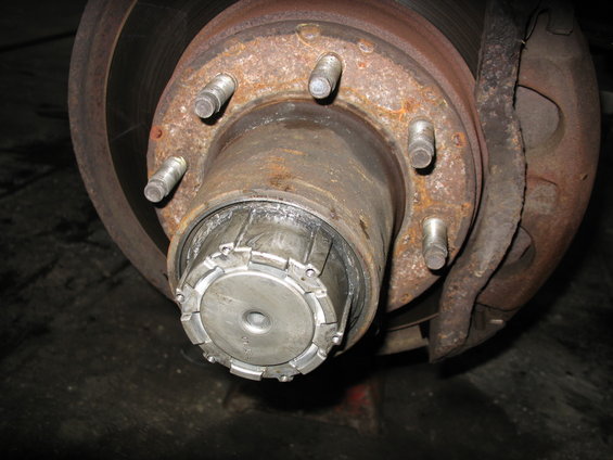 Front wheel hub with lug nuts and brake caliper