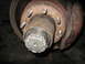 1995 Ford C-350 (Centurion Conversions) - Close-up view of a front wheel hub assembly, showing the brake rotor, lug nuts, and caliper.