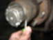 1995 Ford C-350 (Centurion Conversions) - A mechanic works on a vehicle's wheel hub assembly, focusing on the castle nut.