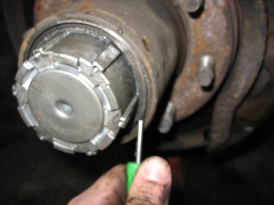 Front axle hub assembly with a tool being used to adjust a locking mechanism