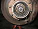 1995 Ford C-350 (Centurion Conversions) - Close-up of a vehicle's front wheel hub and brake assembly, showing internal mechanical components.