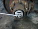 1995 Ford C-350 (Centurion Conversions) - A socket wrench is used to turn a nut on a vehicle's wheel hub.