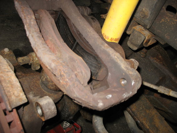 Close-up of rusty front suspension parts, including a shock absorber