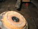 1995 Ford C-350 (Centurion Conversions) - Close-up of a heavily rusted wheel hub and axle shaft, suggesting a vehicle part in need of repair or replacement.