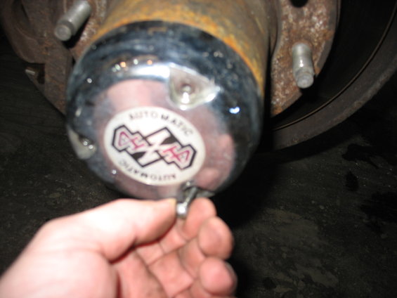 Close-up of a chrome 4x4 automatic hubcap with text around the edge