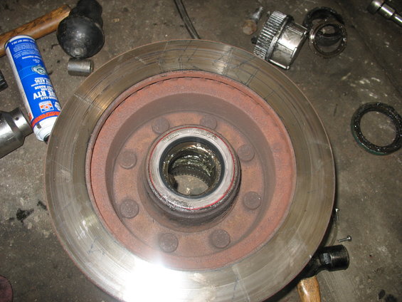 Brake rotor and hub assembly with grease, bearing, and tools including a hammer and spray can