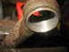1995 Ford C-350 (Centurion Conversions) - A close-up view of a rusty metal pipe fitting, likely a vehicle part, with visible wear inside the interior.