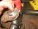 1995 Ford C-350 (Centurion Conversions) - Close-up of a greased driveshaft with splines and a u-joint assembly, likely for a vehicle's front axle rebuild.