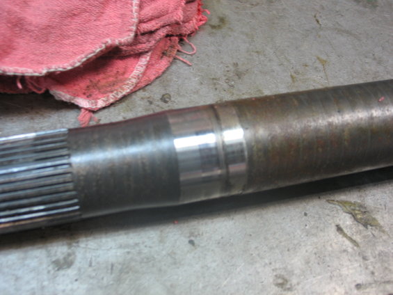 Metal shaft with splines on the left and two distinct wear bands on the right