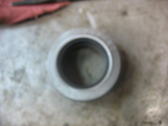 Metal bearing part on a concrete surface with a red cloth in the background