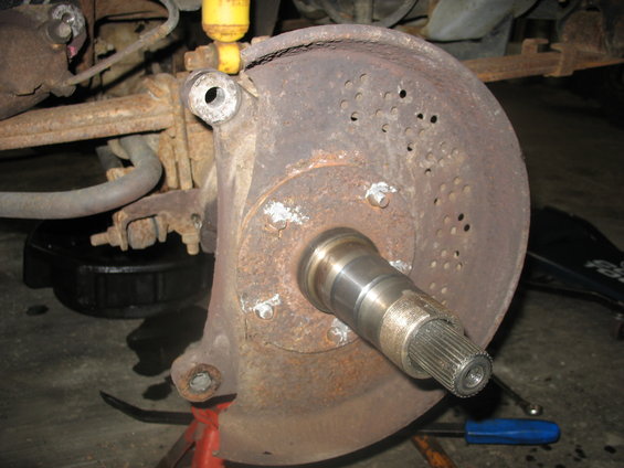 Front wheel hub and brake rotor assembly with yellow shock absorber visible above