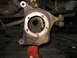 1995 Ford C-350 (Centurion Conversions) - Close-up of a heavily rusted front wheel knuckle assembly, likely undergoing repair or inspection.