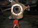 1995 Ford C-350 (Centurion Conversions) - This is a close-up view of a vehicle's front wheel hub assembly, which is currently supported by a red jack stand.