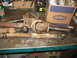 1995 Ford C-350 (Centurion Conversions) - Several heavily rusted automotive parts, including a driveshaft and steering components, are laid out on a metal surface.