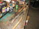 1995 Ford C-350 (Centurion Conversions) - Various front axle components, including tie rods and driveshaft parts, are laid out on a workbench, likely for a rebuild or repair.