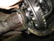1995 Ford C-350 (Centurion Conversions) - Mechanic's hand adjusting a part of the differential assembly, showing gears and driveshaft.
