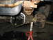 1995 Ford C-350 (Centurion Conversions) - Close-up of a vehicle's rear axle differential during a repair, with fluid draining into a pan.