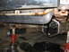 1995 Ford C-350 (Centurion Conversions) - The differential of a vehicle is exposed for maintenance, with tools and oil pans visible on the garage floor.