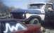 1978 Ford Bronco - A blue and white Ford truck is parked closely behind a red car, with a person visible in the driver's seat.