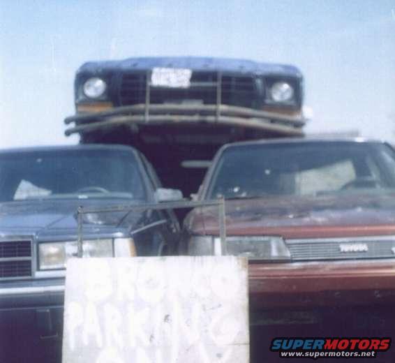 1978 Ford Bronco, blue, front view, on a car carrier with other vehicles