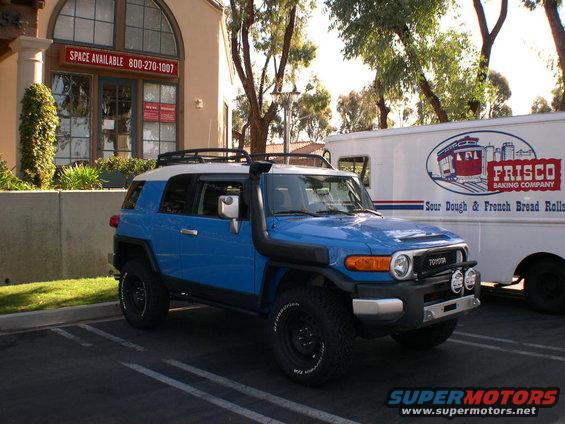 Blue 2007 Toyota FJ Cruiser parked next to a Frisco Baking Company truck