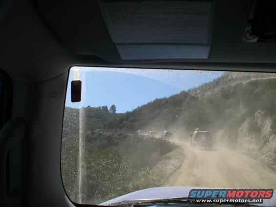 Dusty dirt road with multiple SUVs