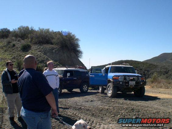 Blue 2007 Toyota FJ Cruiser with front brush guard and auxiliary lights parked on a dirt road