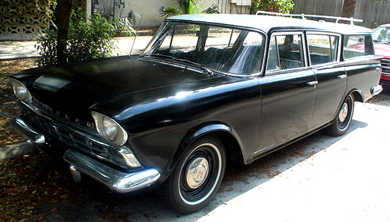 Black station wagon with silver roof and roof rack, front quarter view