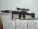 1985 Ford Bronco - A sniper rifle with a scope and bipod is displayed on top of several boxes.