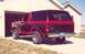 1984 Ford Bronco - Rear view of a two-tone red and black Ford Bronco with a chrome bumper.
