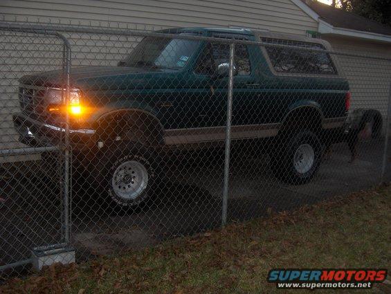 Green 1996 Ford Bronco parked behind a chain-link fence
