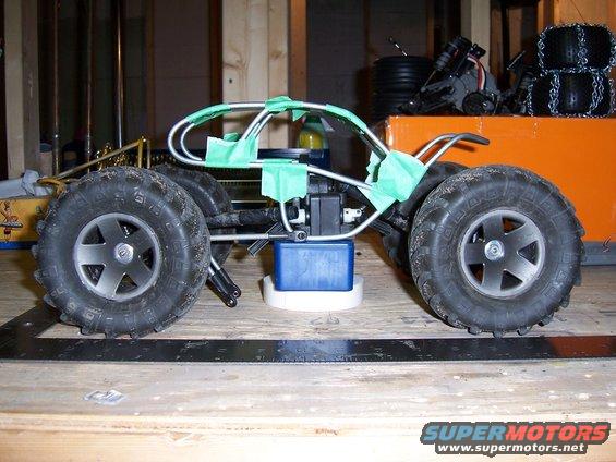 RC car chassis with large tires and green tape on frame