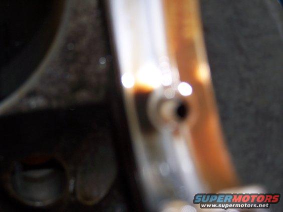 Close-up of an engine part, possibly a connecting rod bearing, showing oil residue